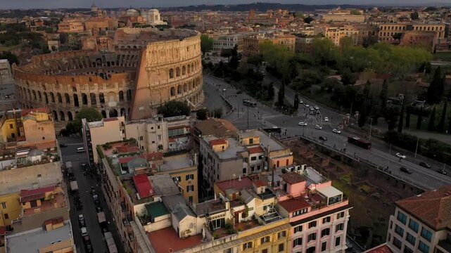 Aerial 4K video footage of Roman Colosseum at sunrise. Ancient amphitheater bathed in golden light.