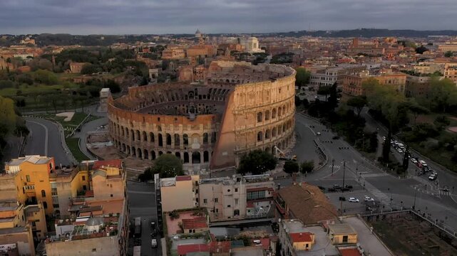 Aerial 4K video footage of Roman Colosseum at sunrise. Ancient amphitheater bathed in golden light.