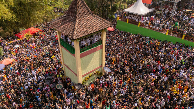 Klaten, Central Java, Indonesia - 31 July 2026: Aerial view of the Yaa Qawiyyu festival, with a massive crowd gathered around a central tower to catch traditional apem cakes.