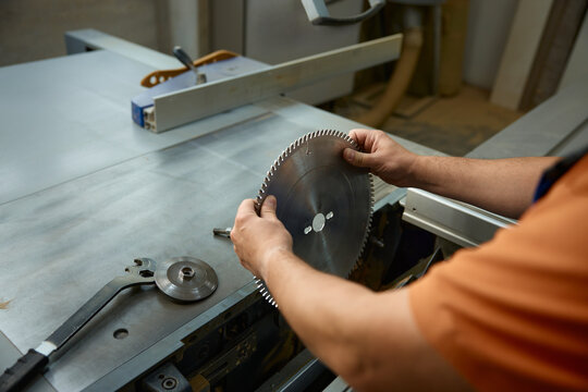 Expert technician precisely aligning saw teeth on metal blade while ensuring safety measures