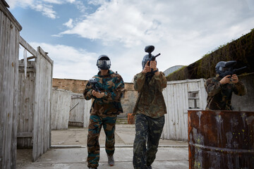 Fototapeta premium An armed group of several people practice with weapons on a training field outdoor