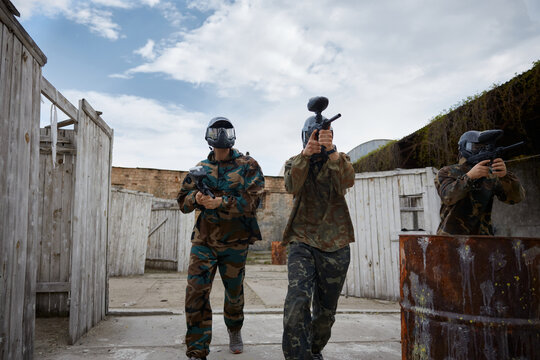 An armed group of several people practice with weapons on a training field outdoor