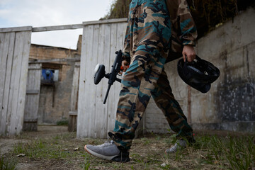 Fototapeta premium Soldier is walking through the training field, holding a weapon and a helmet