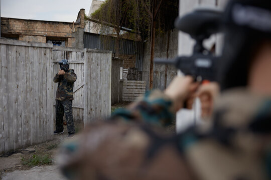 Two soldiers point guns at each other on a training field