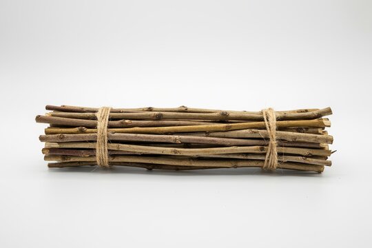 A bundle of dry wooden twigs tied with twine isolated on white background
