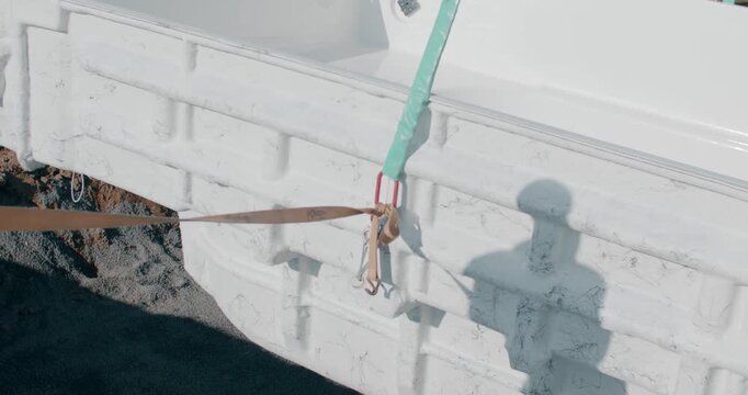 White marble block lifted with sling straps and steel hooks at quarry