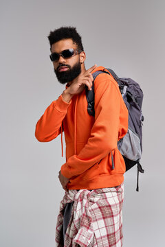 Stylish young man in cozy attire poses confidently with a backpack