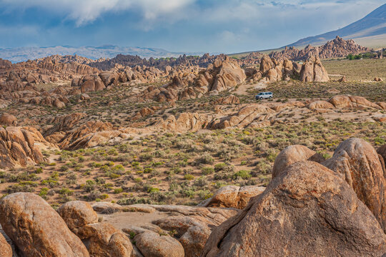 Beautiful scenic view of Alabama Hills rocky desert landscape with a car on a trail
