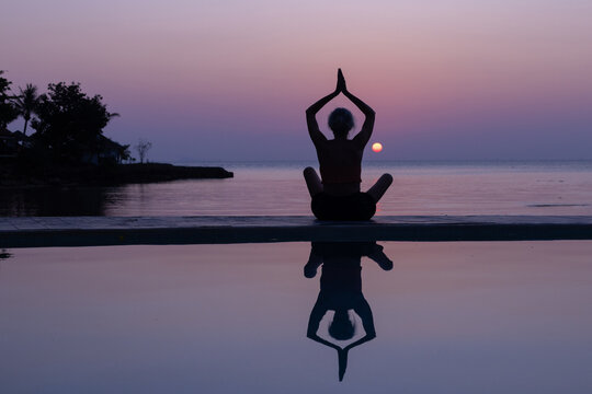 silhouette of woman practicing yoga at sunset