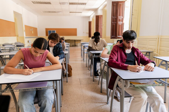 Diverse students concentrating on school exam in classroom