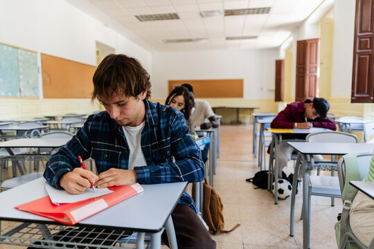 Students taking exam in bright classroom at school