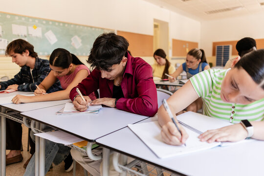 Diverse students studying and writing during school lesson