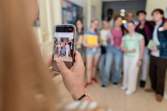 Person recording diverse student group with smartphone
