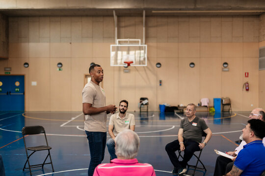 Diverse group of adults listening to speaker during casual meeting