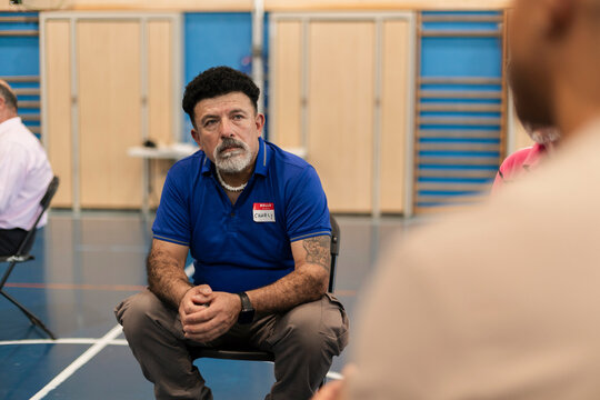 Mature man attending group therapy session listening intently