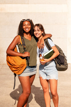 Teenage girls with backpacks embracing student life