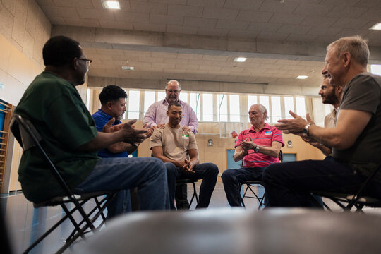 Diverse men clapping, supporting, celebrating achievement in
