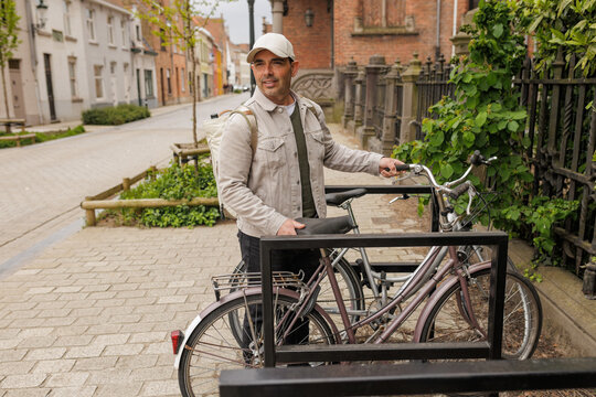 Mid Adult Man Parking Vintage Bicycle in Bruges Bike Rack