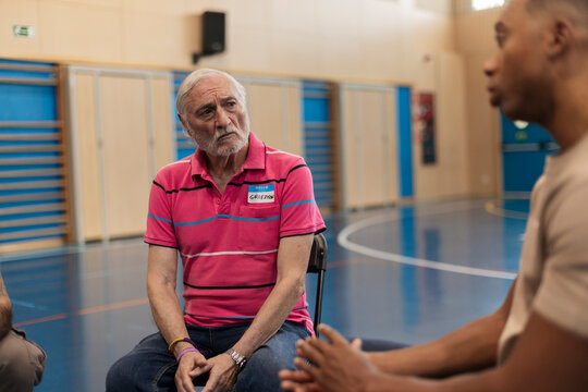 Senior man listening attentively during group discussion