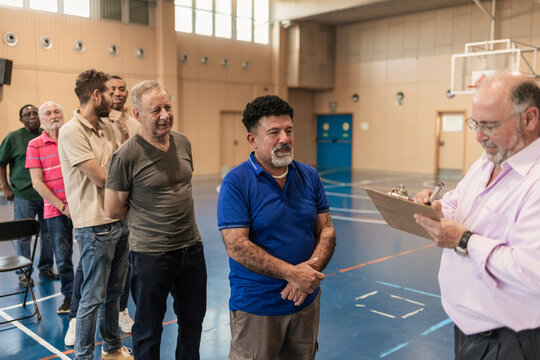 Diverse men registering for community program in gym