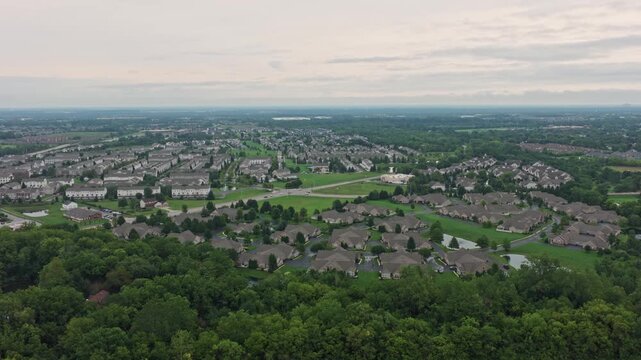 Drone aerial above city of Hilliard, Ohio suburban landscape as a suburb outside Columbus, OH with townhomes, residential units, duplex homes, houses, and rental buildings in middle class neighborhood