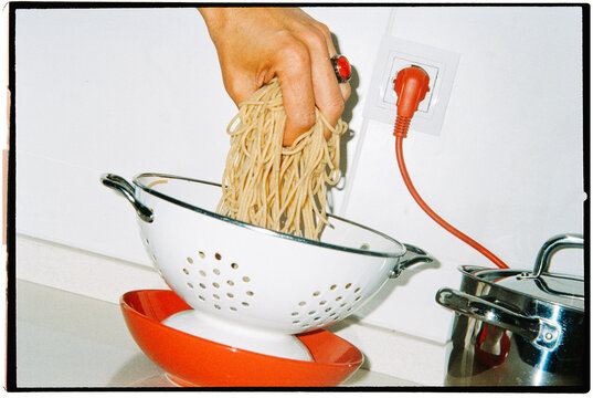 a colander catches freshly cooked spaghetti, 35mm film