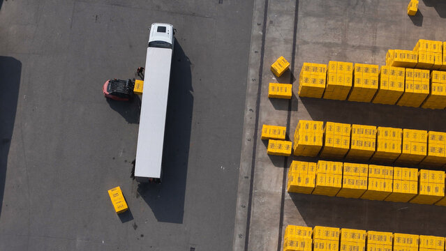 Pontenure, Emilia-Romagna, Italy - 30 March 2026: Aerial view of Ytong autoclaved aerated concrete blocks stacked on yellow pallets being loaded by a forklift onto a truck in an industrial yard.