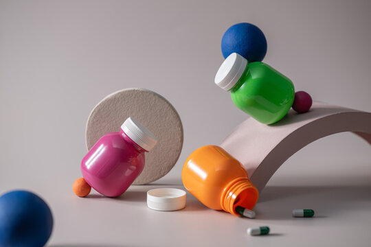 Colorful medicine bottles and capsules arranged in a playful setting