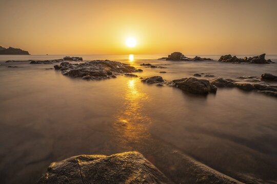 The sun rises on the horizon over the sea in Sardinia, Sardinia Italy