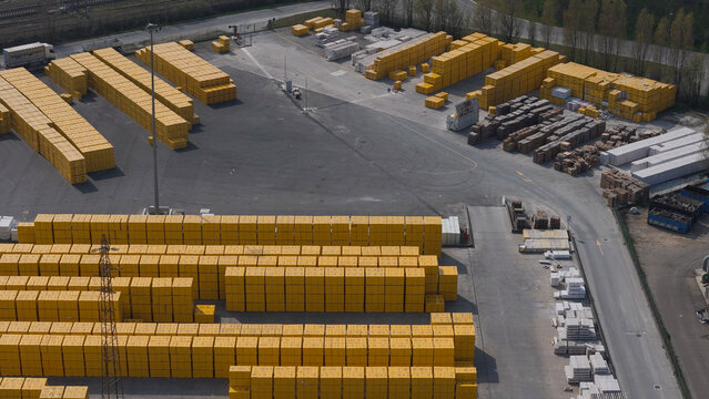 Pontenure, Italy - 30 March 2026: Aerial view of the YTONG Xella Italia facility, showing large stacks of yellow-wrapped aerated concrete blocks in an industrial yard.