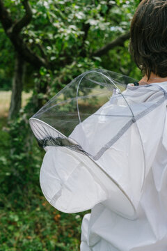Female bee keeper in a white protective suit