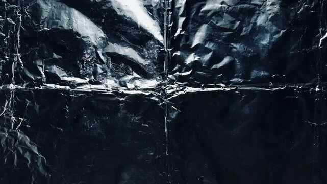 crumpled black foil texture radiating metallic creases evoking moody darkness for web design and advertising backdrop