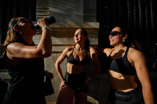 Women enjoying a break while exercising outdoors in warm sunligh