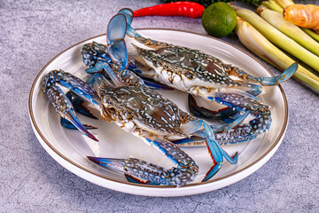 Fresh blue crabs on white plate with lime chili and lemongrass © Andrei Starostin