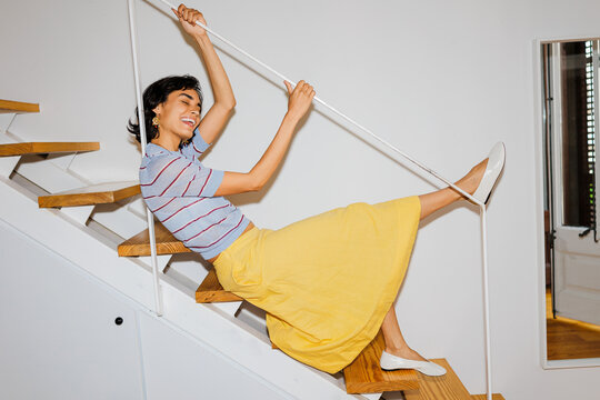 Woman sliding down staircase having fun ugc
