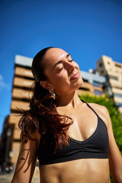 Woman enjoys sunshine in a city on a clear day