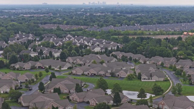 Drone aerial above city of Hilliard, Ohio suburban landscape as a suburb outside Columbus, OH with townhomes, residential units, duplex homes, houses, and rental buildings in middle class neighborhood