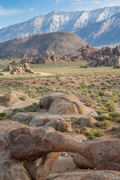 Beautiful vertical view of a natural stone arch and Sierra Nevada mountains in Alabama Hills