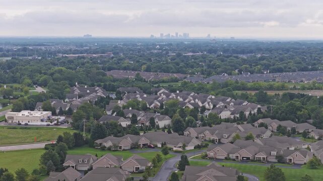 Drone aerial above city of Hilliard, Ohio suburban landscape as a suburb outside Columbus, OH with townhomes, residential units, duplex homes, houses, and rental buildings in middle class neighborhood