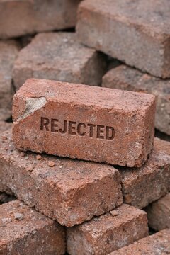 A pile of bricks marked as rejected with the word 'rejected' written on them