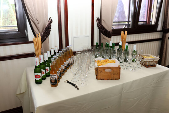 Stella Artois and Corona Extra bottles, glasses, chips and breadsticks arranged on a table for a festive event.