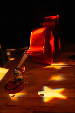 upright string bass resting on a stage with star stage lighting