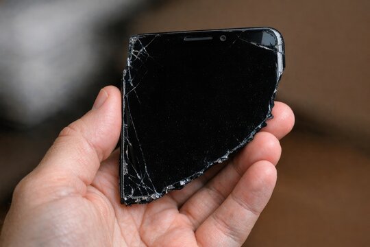 A person is shown holding a broken cell phone, possibly needing repair or replacement