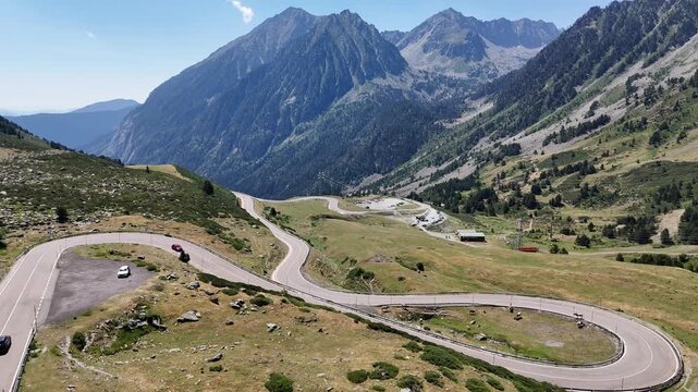 Cars driving on a winding mountain road in the Pyrenees