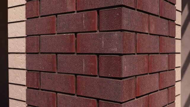 Red brick facade corner with contrasting light bricks close up