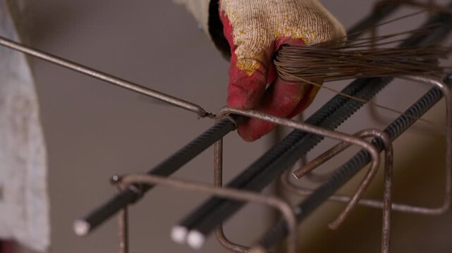 Worker tying reinforcing steel bars with binding wire