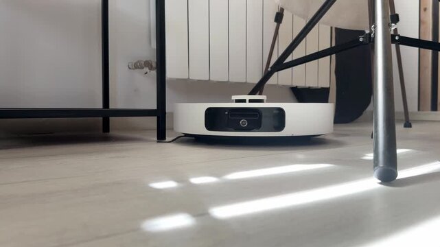Robot vacuum cleaner automatically navigating across a floor and avoiding obstacles, smart home cleaning technology in action, autonomous household appliance moving around a room
