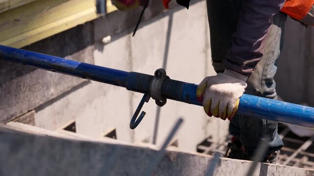 Worker tightening construction beam connection with hammer
