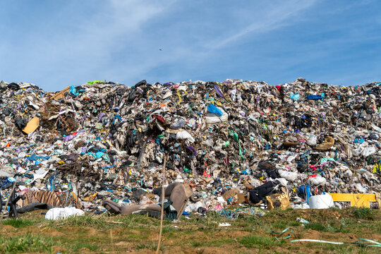 Large pile of waste seen in open area during daylight, showing various types of discarded materials