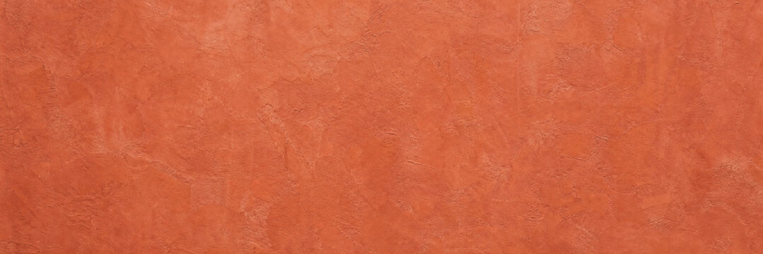 Terracotta orange stucco wall texture, rustic clay plaster background with grainy surface detail. Earthy red concrete stone finish, warm Mediterranean architectural wall for design backdrop.